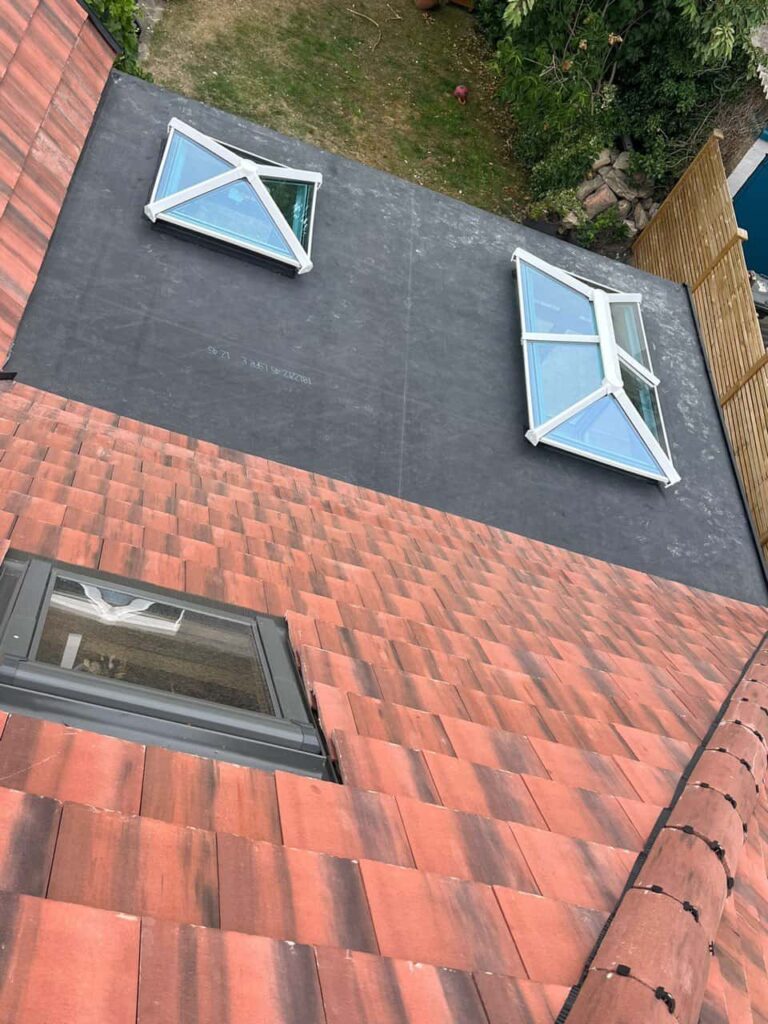 This is a photo taken from the roof ridge looking down a tiled pitched roof on to a flat roof. Works carried out by LS Roofing Wendover